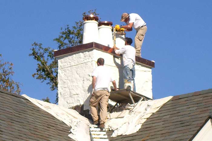 Technicians performing  renovations on a chimney system