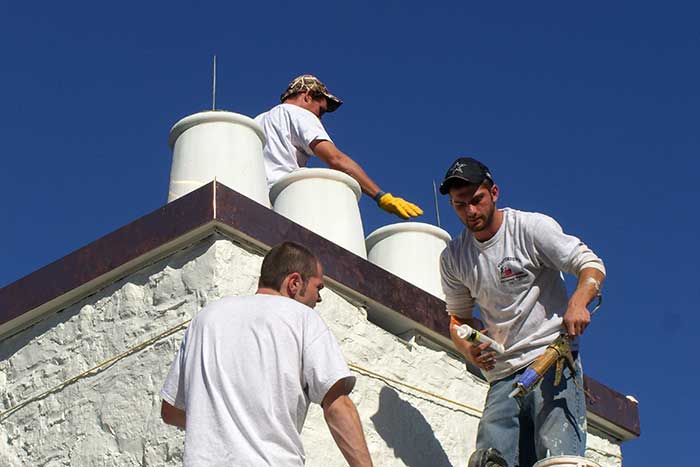 Technicians performing renovations and repair work on a chimney system